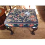 A George III style mahogany stool, the woolwork seat over a gadrooned edge and acanthus carved