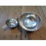 A silver small bowl on single foot and a silver plated tea strainer