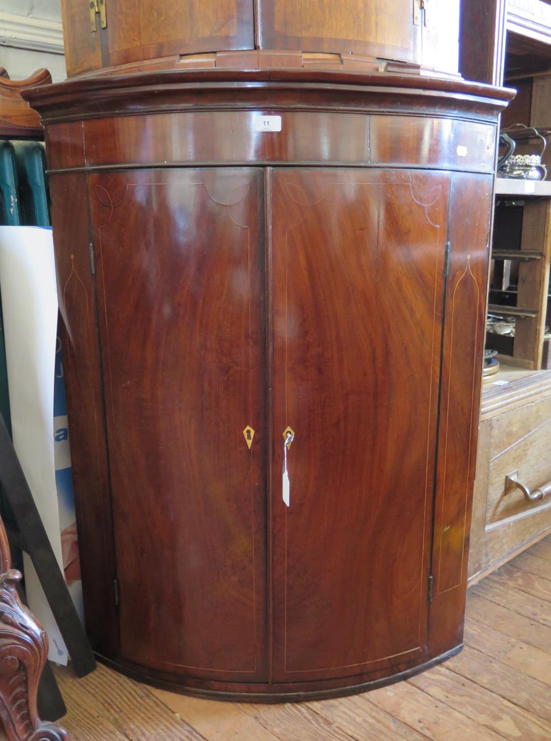 An early 19th century boxwood inlaid mahogany bowfront corner cupboard, with three shelves, 84 cm