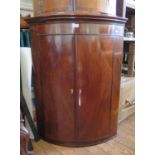 An early 19th century boxwood inlaid mahogany bowfront corner cupboard, with three shelves, 84 cm