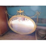 A George III style giltwood oval mirror, the bevelled plate within a tongue and dart frame