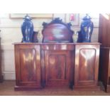 A Victorian mahogany sideboard, the raised back with foliate scrolls above a serpentine drawer and