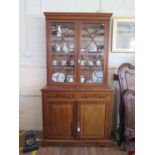 An Edwardian mahogany and satinwood crossbanded bookcase cabinet, the inlaid dentil cornice over a