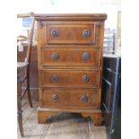 A reproduction crossbanded yew wood bachelor's chest, the hinged top enclosing a leather surface,