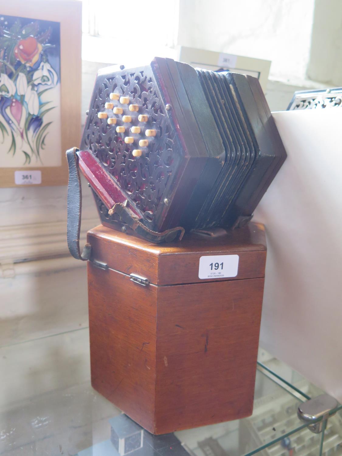 A cased concertina, possibly by Lachenal, with 31 bone keys in a fretwork frame, one end with