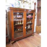 A 1920s mahogany display cabinet, the twin glazed doors on shell carved cabriole legs, 117 cm wide