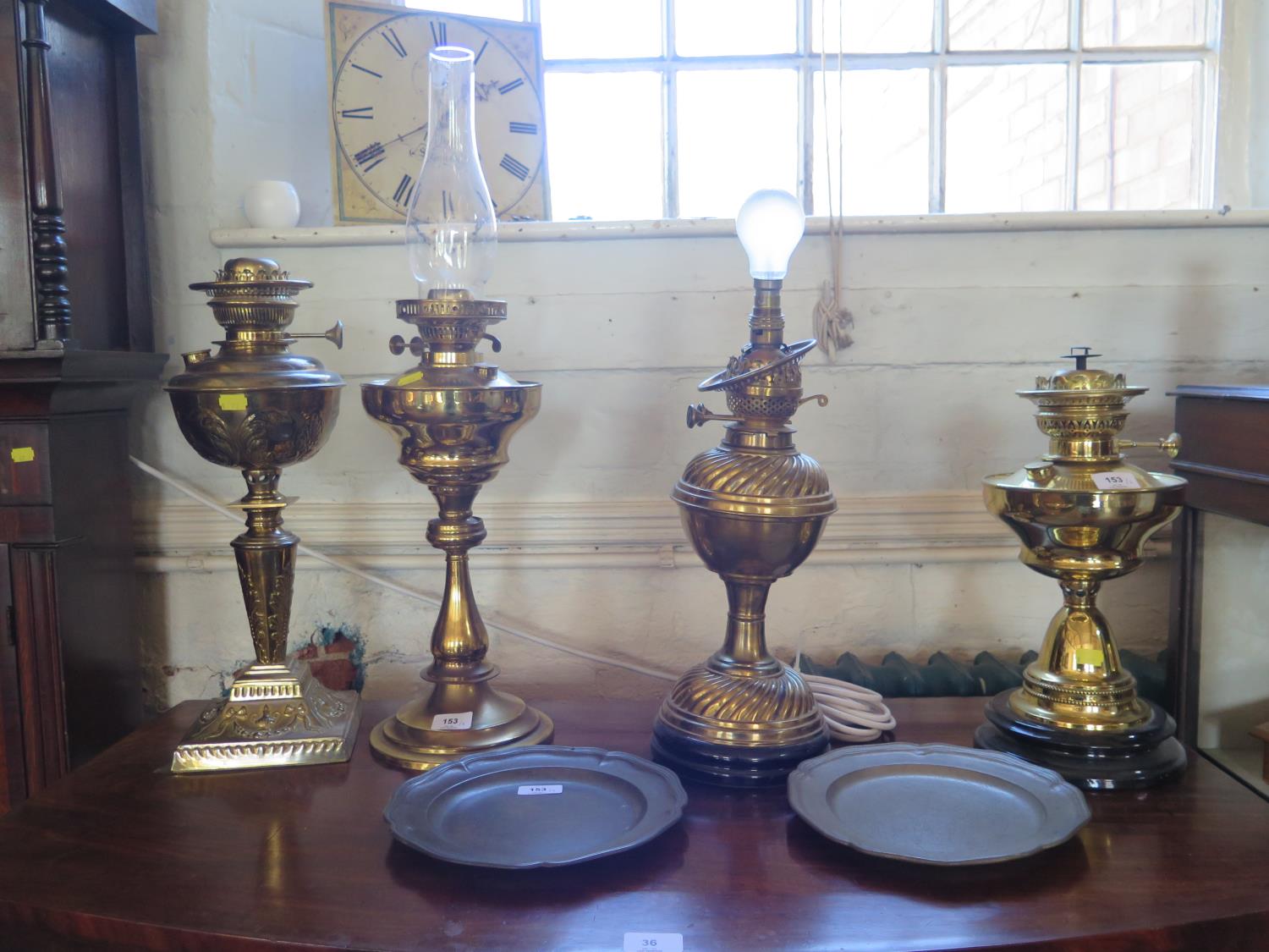 An Edwardian brass oil lamp, with repousse foliate decoration, tapering stem and square base, 48