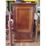 A late Victorian mahogany music or collector's cabinet, the moulded top over a panelled door with