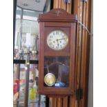 A 1920s oak wall clock, with silvered dial and bevel glazed door, 78 cm high