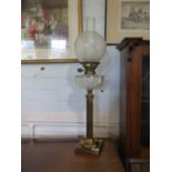 A brass column oil lamp, with facetted glass reservoir and fluted stem with square base, 63 cm high