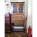 An Edwardian oak bureau bookcase, with lead glazed doors, over a sloping fall, and open shelves,