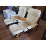 A pair of Ekornes 'Stressless' cream leather armchairs and stools, with swing tables, on circular