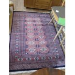 A Pakistani rug, the deep blue and grey medallions on a red field within a serrated multiple border,