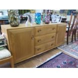 An Ercol elm Windsor sideboard, with three central drawers (the top drawer with cutlery insert)