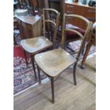 A pair of bentwood dining chairs, with solid seats and metal brackets