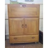 An Ercol elm Windsor serving cabinet, the fall front enclosing adjustable shelves, over a pair of