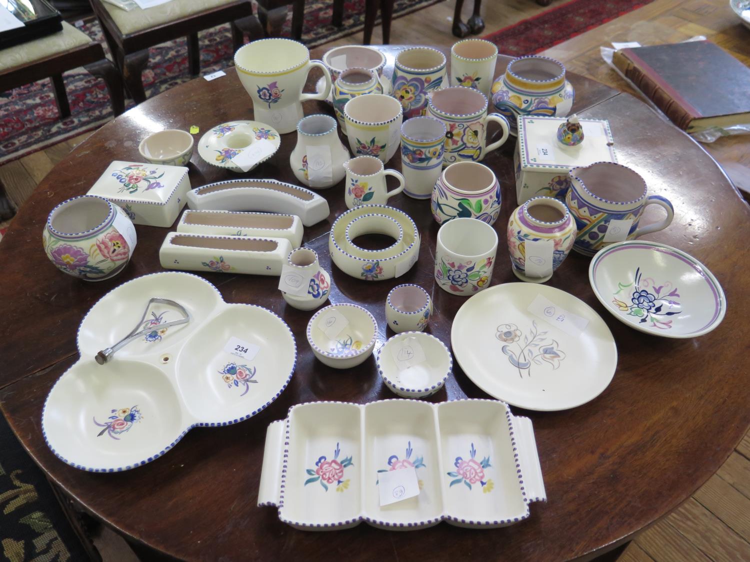 A collection of Poole Pottery, including small vases, jugs, boxes and serving dishes, all with