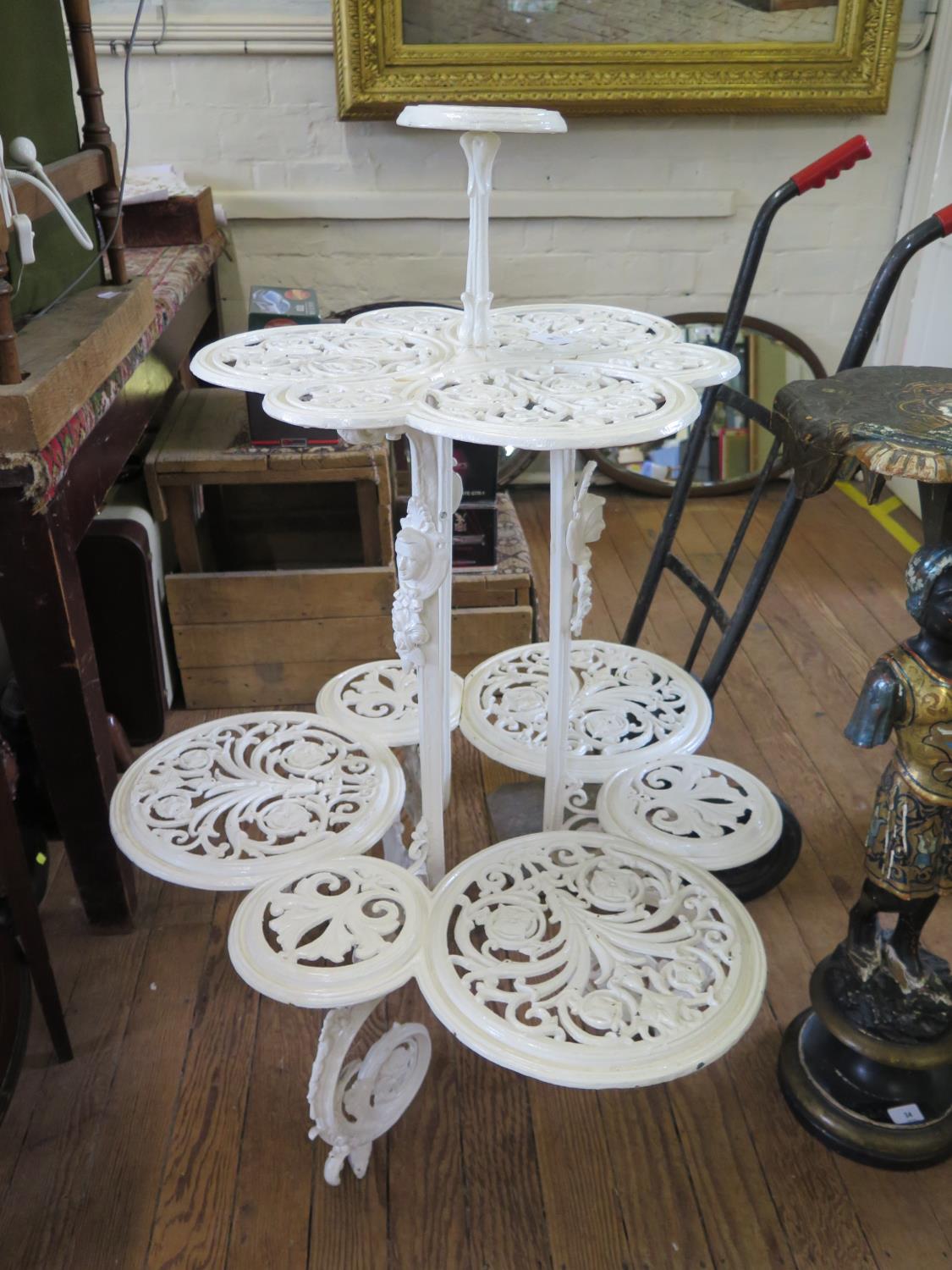 A Victorian painted cast iron three tier plant stand, in the style of Coalbrookdale, each tier