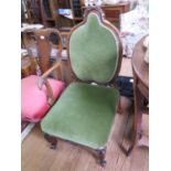 A Victorian walnut framed low nursing chair with heart shaped back upholstered in green dralon plush