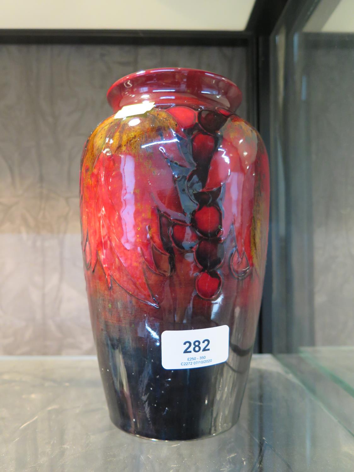 A Moorcroft Pottery grape design vase, with red glaze, signed William Moorcroft and impressed