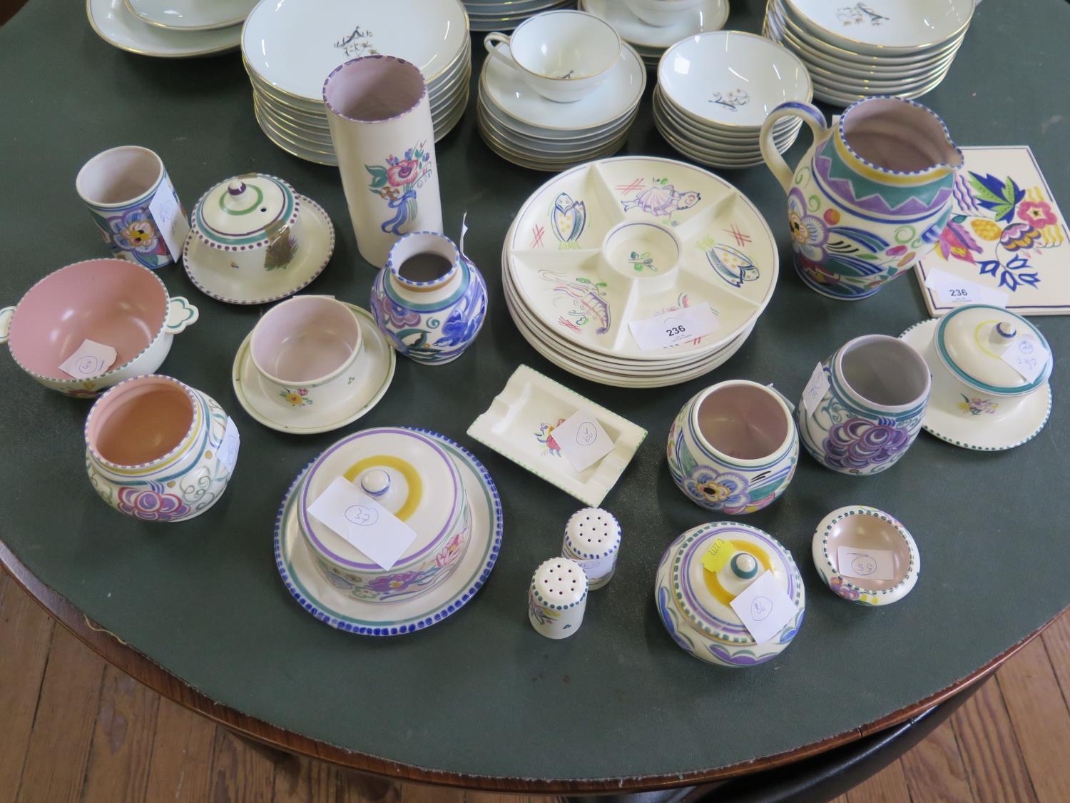 A collection of Poole Pottery, including a tile, plates, covered dishes, jars and an ashtray, all