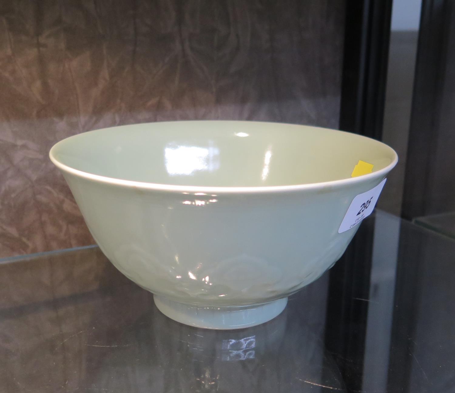 A Chinese celadon bowl, with moulded lotus design, seal mark on the base, 18 cm diameter
