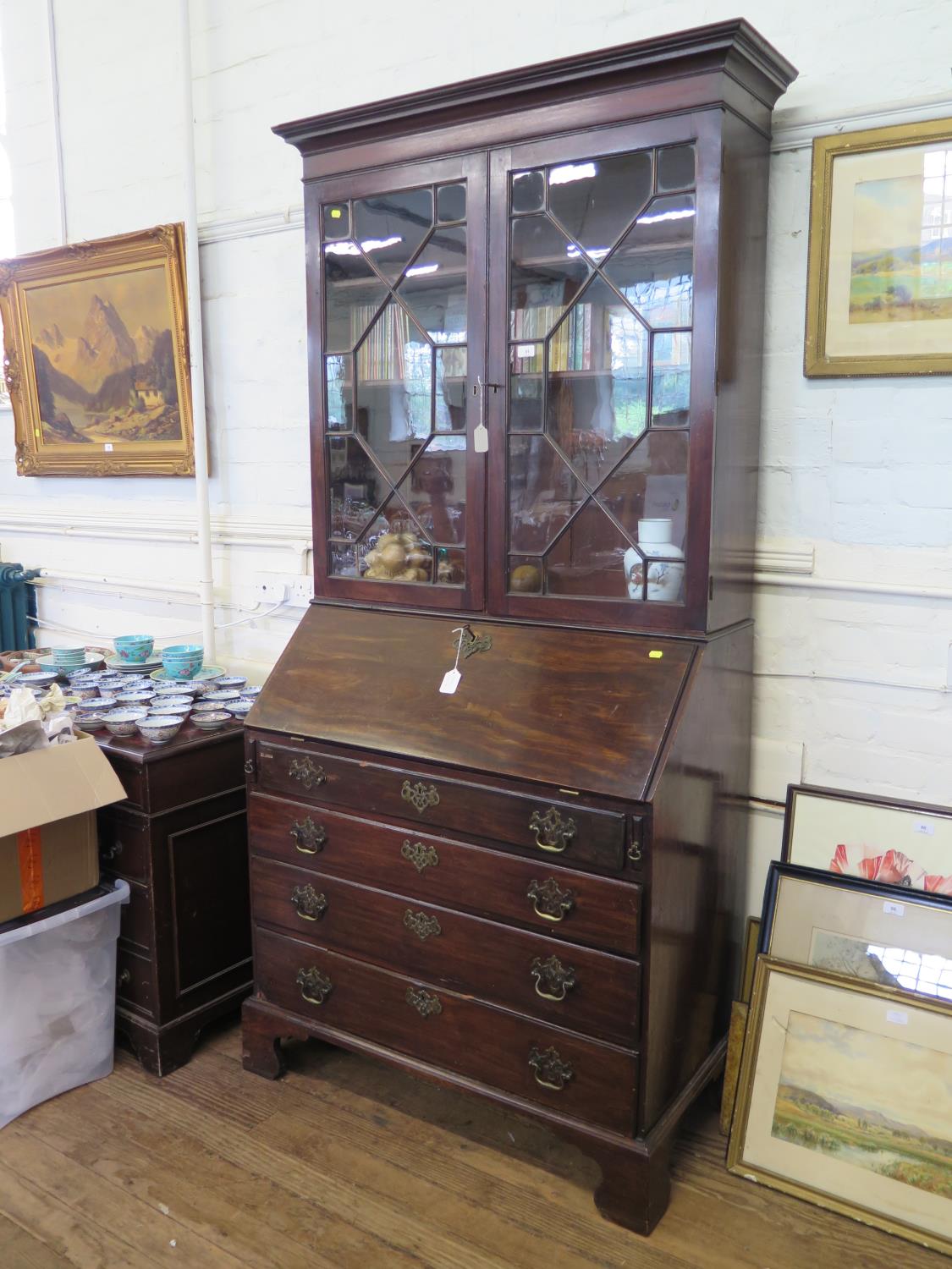 A George III mahogany bureau bookcase, the astragal glazed twin doors over a sloping fall above four