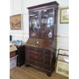 A George III mahogany bureau bookcase, the astragal glazed twin doors over a sloping fall above four