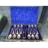 A cased set of twelve silver spoons with two pairs of silver tongs, bright cut decoration