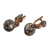 A pair of diamond earrings set in 14 carat gold