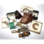 A bag containing a selection of costume jewellery - brooches, bracelets, necklaces, etc