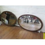 An oval oak framed wall mirror, with bevelled plate and cabochon carving, 85 cm wide, and another