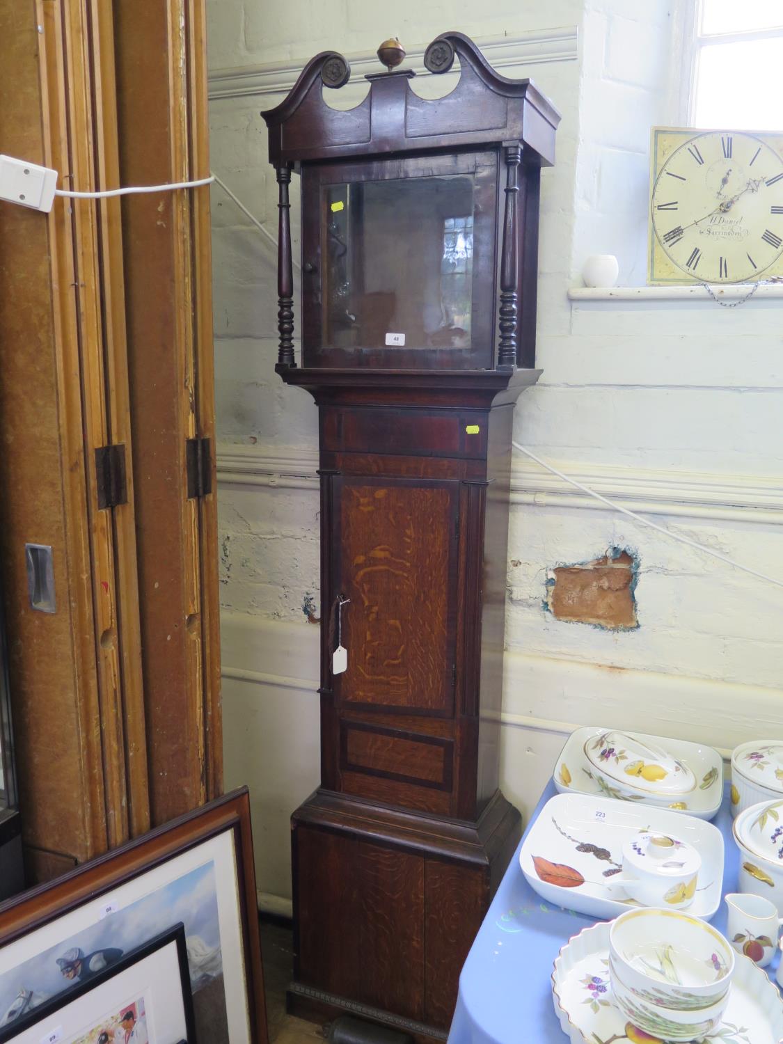 An early 19th century oak and mahogany crossbanded longcase clock, the swan neck pediment over a