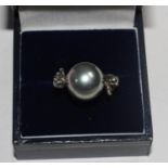 A Misaki 925 silver pearl ring with two cats seated either side of the pearl, in box