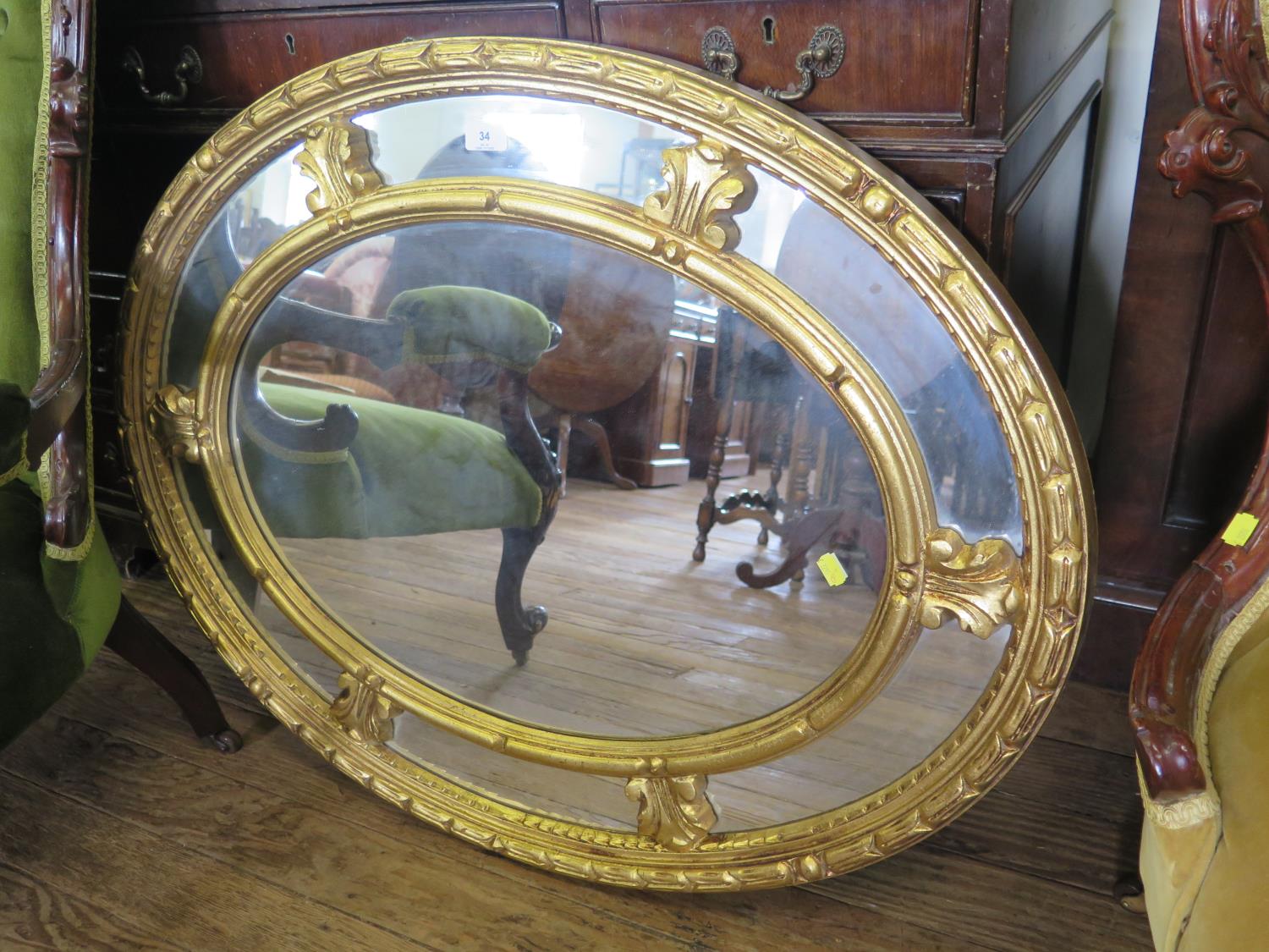 An oval giltwood wall mirror, with panelled border, 92 cm x 72 cm, and a shaped giltwood mirror