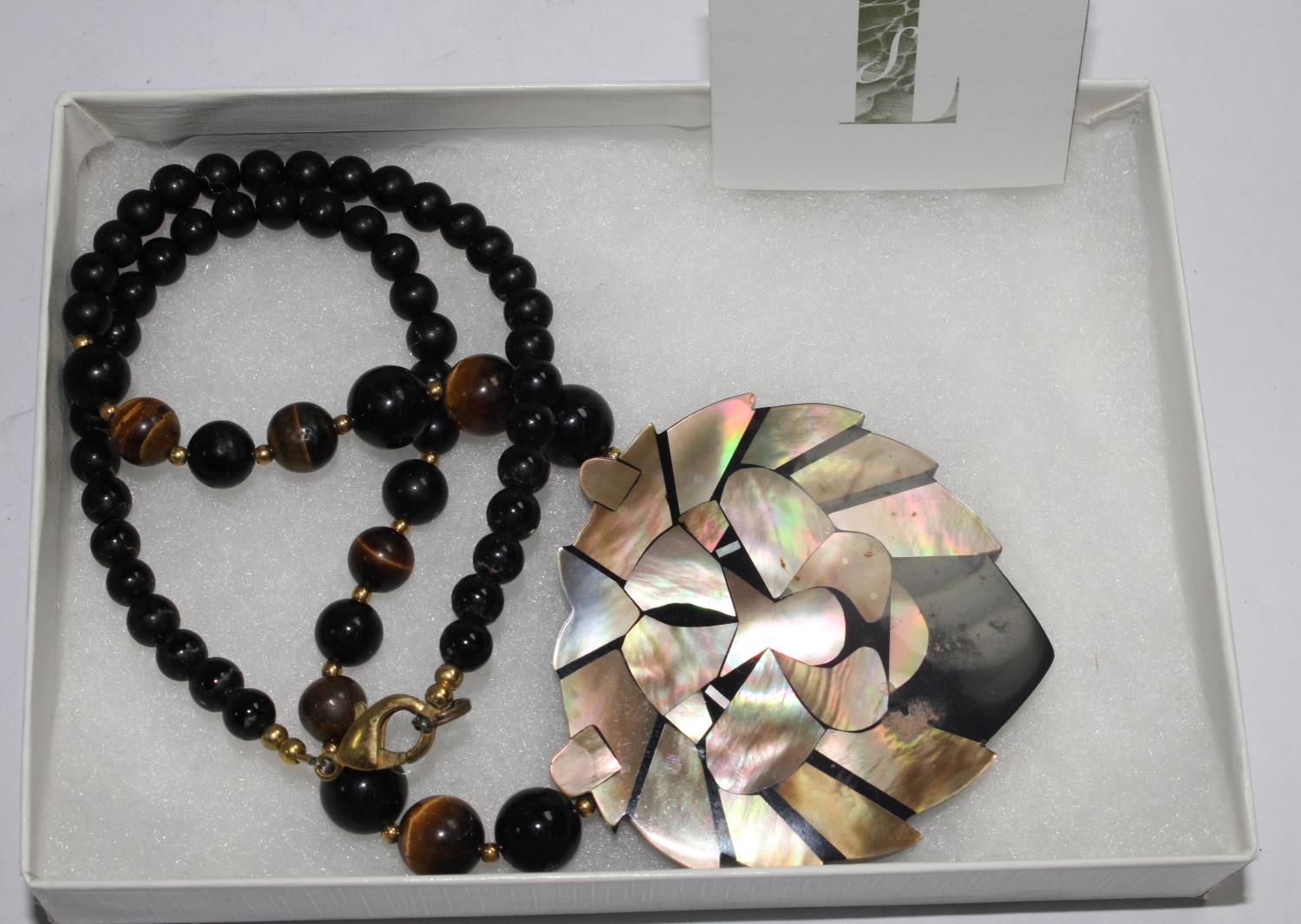 A Lee Sands tigers eye and mother of pearl lion necklace, in box