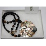 A Lee Sands tigers eye and mother of pearl lion necklace, in box