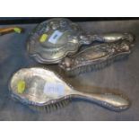 A ladies silver hand mirror and brush and another silver brush