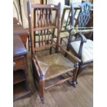 A Lancashire spindle back rocking chair, with turned arms, rush seat and turned legs with pad feet