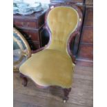 A pair of mid Victorian lady's and gentleman's salon chairs, carved with scrolls, the button spoon