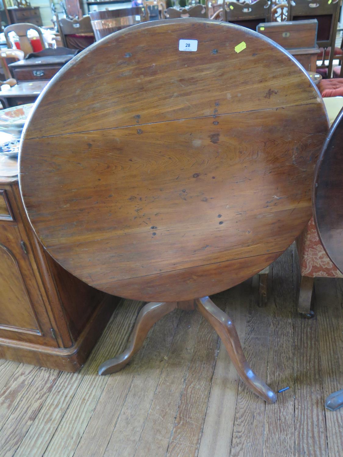 A George III elm snap-top tripod table, the circular top on a turned baluster stem and cabriole
