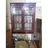 An Edwardian mahogany display cabinet, the fluted and rosette frieze over a pair of glazed doors
