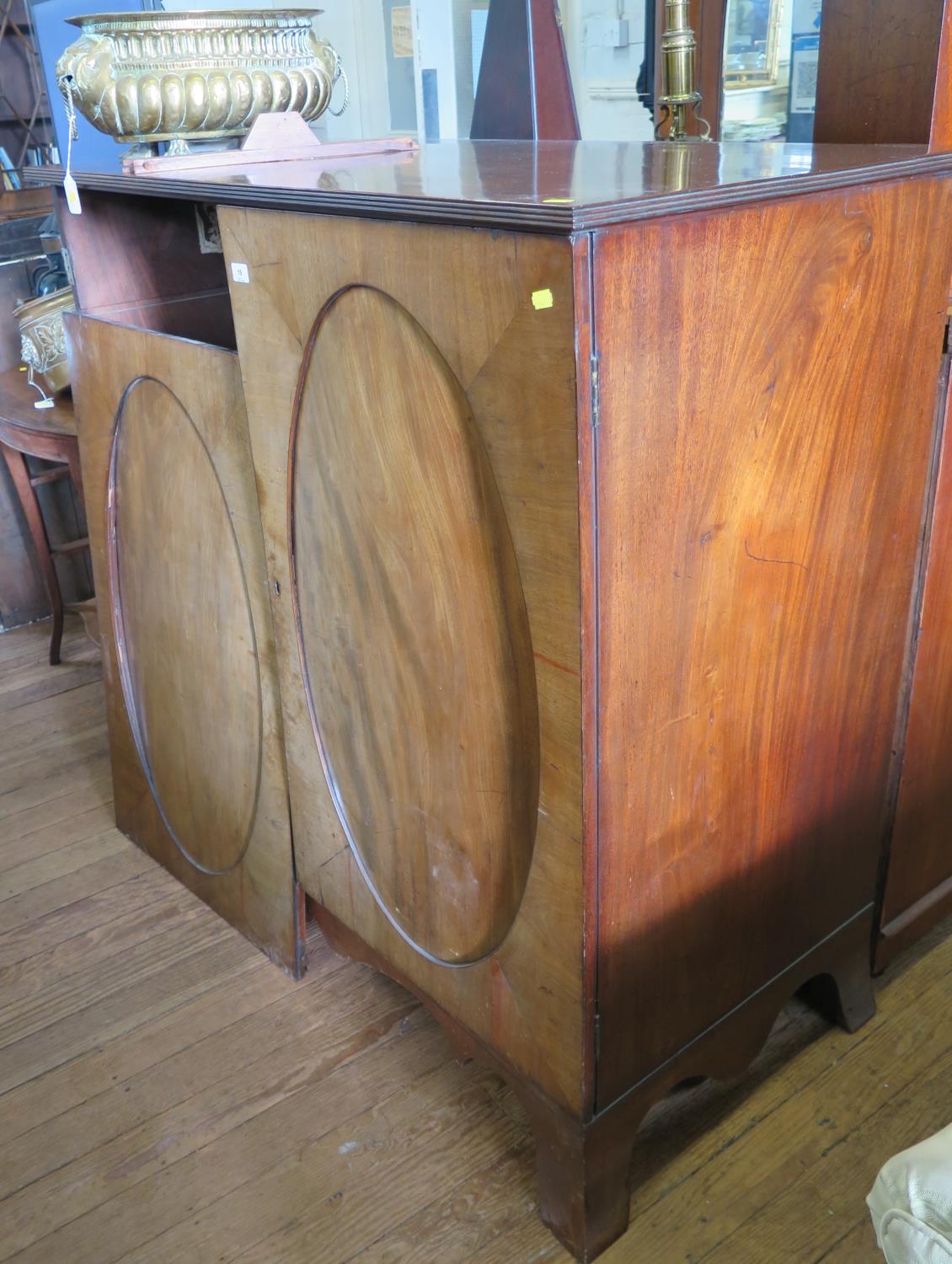 An early 19th century mahogany cabinet, converted to a TV cabinet, with twin oval panelled doors