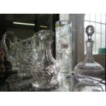 A cut glass crystal water jug/pitcher together with two small decanters and a vase