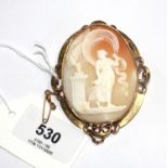 A large shell cameo brooch depicting a Grecian lady holding a snake whilst watching a fox, the cameo