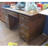 An Edwardian oak pedestal desk, the leather inset top over three frieze drawers and three further