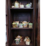 A collection of cottage form teapots, milk jugs and boxes