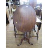 A 19th century mahogany snap-top tripod table, the oval top on a baluster stem and scrolled legs,