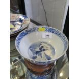 A Chinese blue and white bowl, with all over design of flowering trees and figures flanking vases,