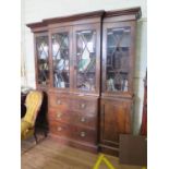 A George III style mahogany breakfront bookcase, the moulded cornice over four astragal glazed doors